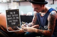 a man with tattoos on his arm is looking at an electronic device that says the 10 best tattoo shops on the las vegas strip