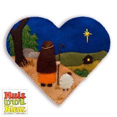 a felt heart with an image of a shepherd and sheep in the field at night