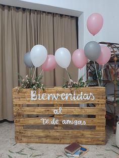 a wooden crate filled with balloons on top of a floor