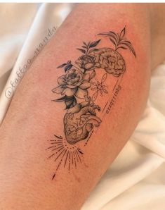 a tattoo on the leg of a woman with flowers and hearts in her heart shape