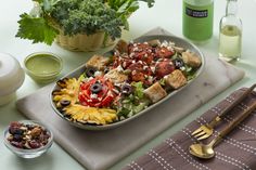 a tray filled with lots of food sitting on top of a table next to bowls and utensils