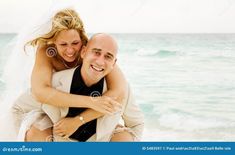 a bride and groom hugging on the beach stock photo - image 398974