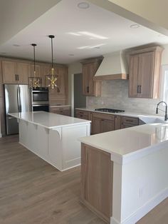 a large kitchen with an island in the middle and wooden cabinets on both sides is shown