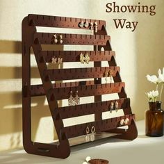 there is a wooden rack with earrings on it and the words showing way above it