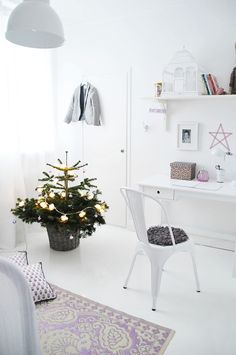 a white room with a christmas tree in the corner