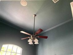 a ceiling fan in a room with blue walls