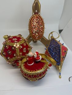 three red and gold ornaments are on display