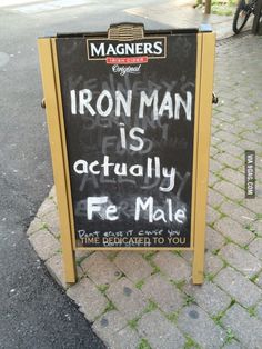 a sign on the sidewalk that says iron man is actually fe male