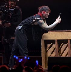 a man taking a selfie with his cell phone in front of him on stage