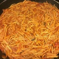 a pan filled with pasta and sauce on top of a stove