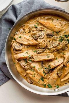 a pan filled with chicken, mushrooms and gravy on top of a table