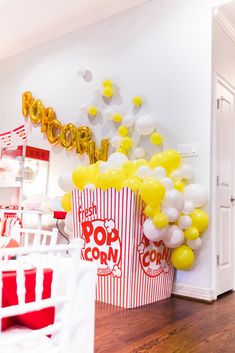 popcorn buckets filled with yellow and white balloons