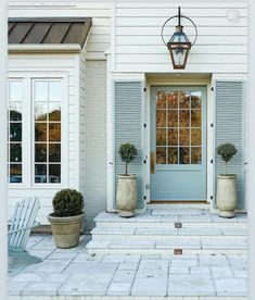 two large planters are sitting in front of a blue door