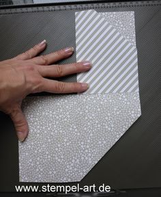 a woman's hand is on top of a piece of paper with white dots