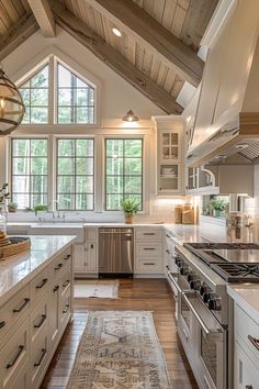 a large kitchen with white cabinets and wood floors, an area rug on the floor