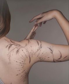 the back of a woman's body with tattoos on her upper and lower arm