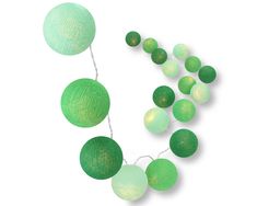 green paper balls and string lights on a white background