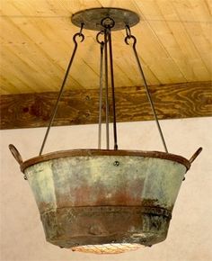 an old light fixture hanging from the ceiling in a room with wood paneled ceilings