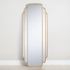 three mirrors sitting next to each other on top of a wooden floor in front of a white wall