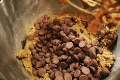 a metal bowl filled with chocolate chips and other food items on top of a table