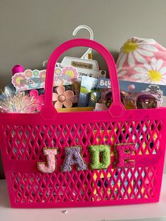 a pink shopping basket with letters on it