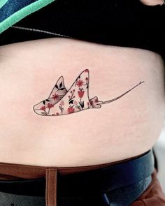 a woman's stomach with a tattoo design on the lower part of her belly