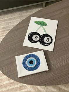 two embroidered patches on a table with an eyeball