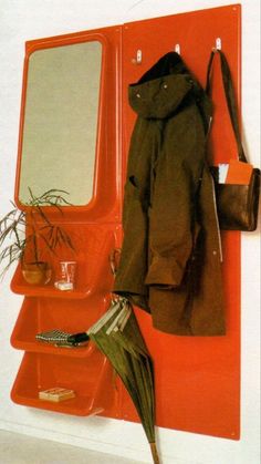 a red coat rack with mirror, umbrella and potted plant