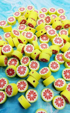 a pile of yellow and red buttons on a blue tablecloth with watermelon slices