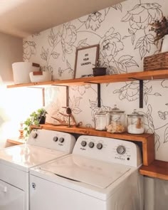 a washer and dryer in a room with floral wallpaper on the walls