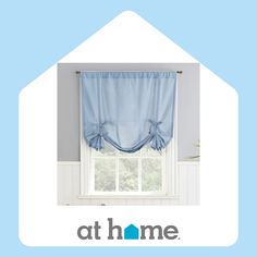 a blue window curtain with the words at home above it and an image of a house