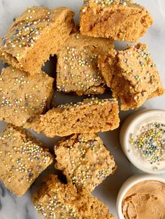 there are several pieces of bread with sprinkles next to some dipping sauce