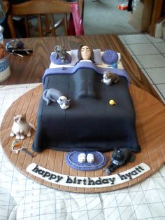 a birthday cake with cats laying on it