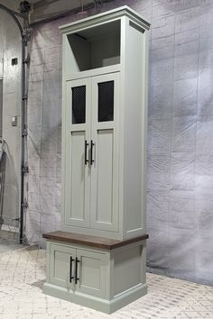 a tall cabinet with two doors and drawers