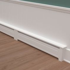 a white bath tub sitting on top of a hard wood floor next to a wall