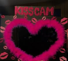 a pink heart shaped wreath with lipstick on it and the word kisscam written in red