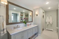 a bathroom with two sinks and a large mirror in it's center area,