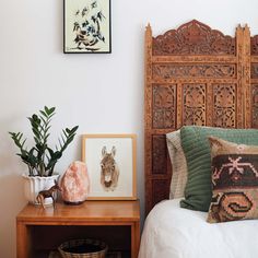 a bed with pillows and pictures on the wall