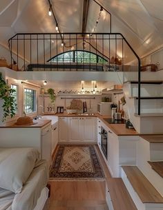 a kitchen with stairs leading up to the loft