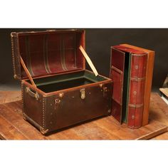 two old suitcases sitting next to each other on top of a wooden table with books