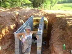 a woman standing next to a construction truck in the middle of a dirt pit with ladders on it