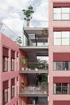 two tall buildings with balconies and plants on the balconys are shown in this image