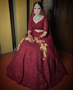 a woman in a red bridal gown sitting on the floor