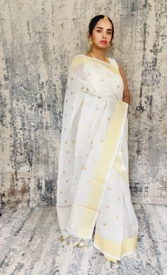 Simple white Kota Check inspired Banarasi saree with good zari dots embroidered all over the body. Zari palli simple and unique. Its just a very simple yet beautiful saree... Color White Saree is light , drapes easily , has a beautiful shine and overall a very good choice. The saree is ready to wear with falls, pico and beautiful handwoven tassels , and unstitched blouse fabric is included. Note: Colors that show up on your screen may vary slightly from the actual product due to variations in settings. Also, the actual product may appear to be different hues depending on the ambience lighting. Note: There may be very slight inconsistencies such as in the weave/motifs work, there being characteristics are not considered defects. Saree does not come with the jewelry shown in pictures. White Handloom Pre-draped Saree For Diwali, Traditional White Chanderi Pre-draped Saree, White Pre-draped Saree With Zari Weaving For Festivals, White Cotton Silk Traditional Wear For Festive Season, White Handloom Pre-draped Saree, Traditional White Pre-draped Saree With Self Design, White Pre-draped Saree With Self Design, White Cotton Silk Traditional Wear With Zari Work, White Cotton Silk Pre-draped Saree For Wedding