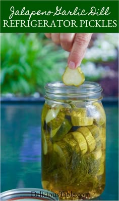 a person picking pickles from a jar