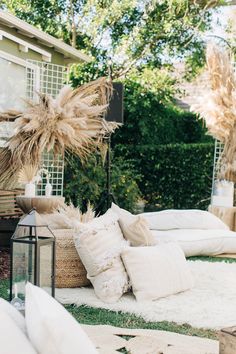 an outdoor seating area with pillows and plants