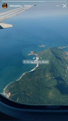 an airplane wing flying over the ocean and land