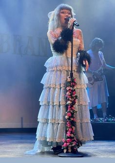 a woman in a white dress holding a microphone