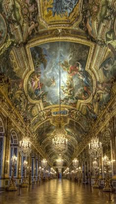 an ornately decorated hall with chandeliers and paintings on the ceiling is shown