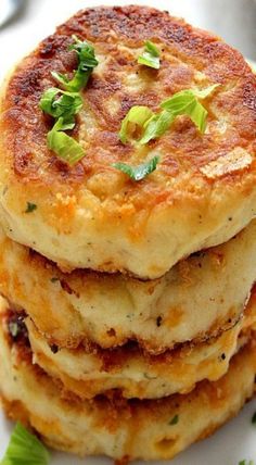 a stack of food sitting on top of a white plate covered in sauce and herbs